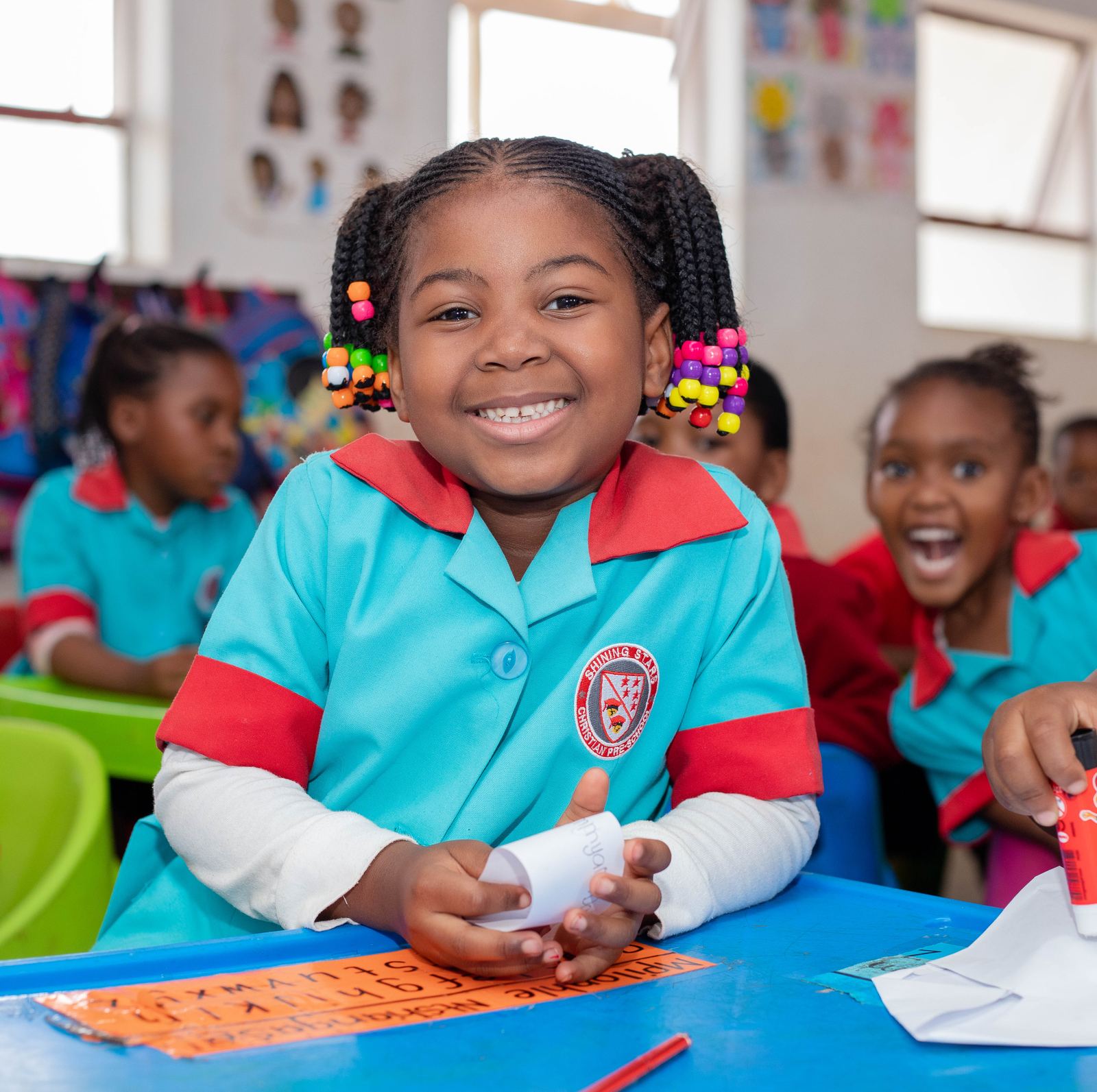 A Shining Stars pupil smiling at her classroom desk